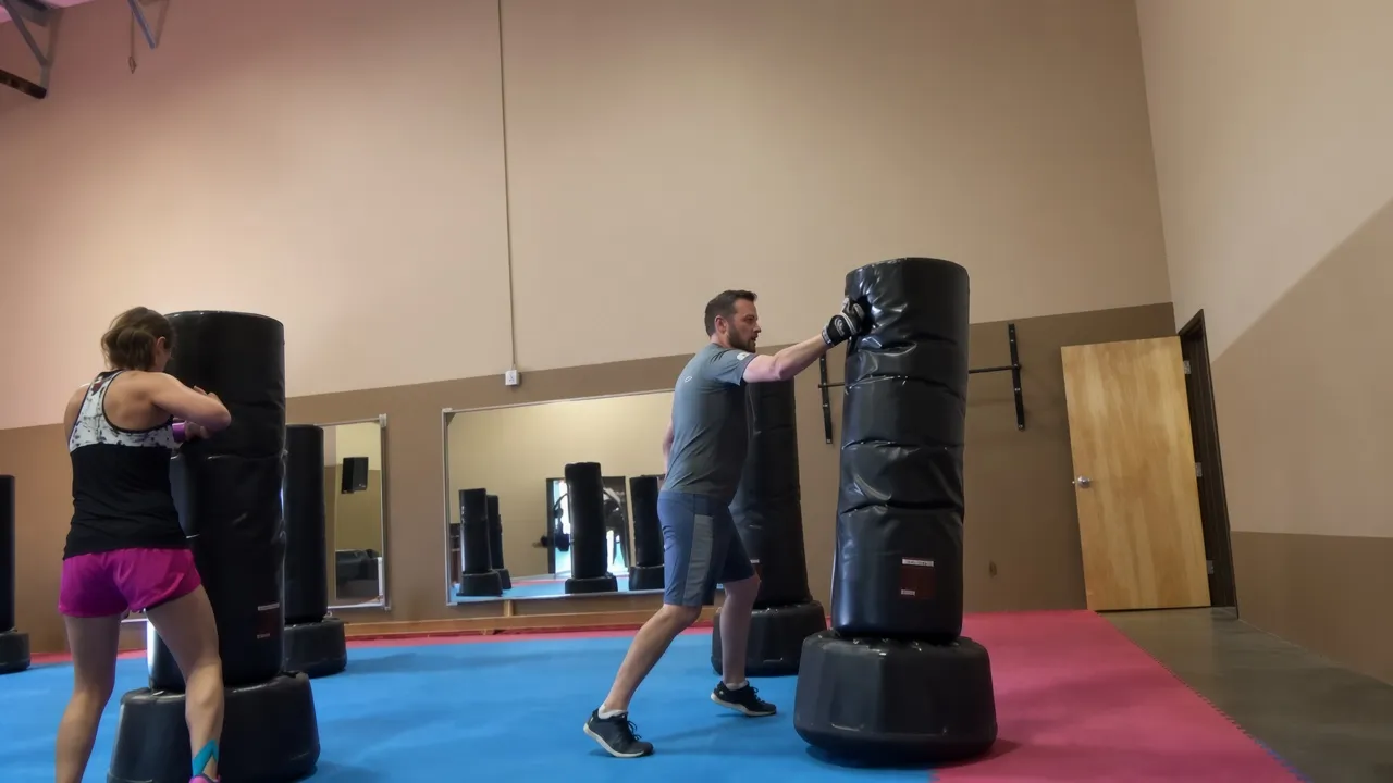 Adults training on heavy bags in a kickboxing class