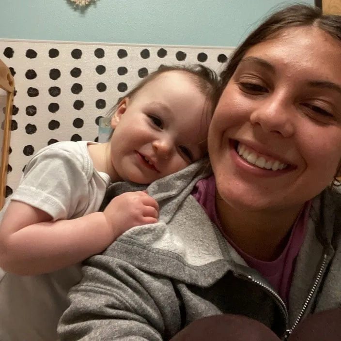 One baby and a teacher smiling together