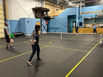 Adults playing indoor pickleball on the court at Bodies in Motion