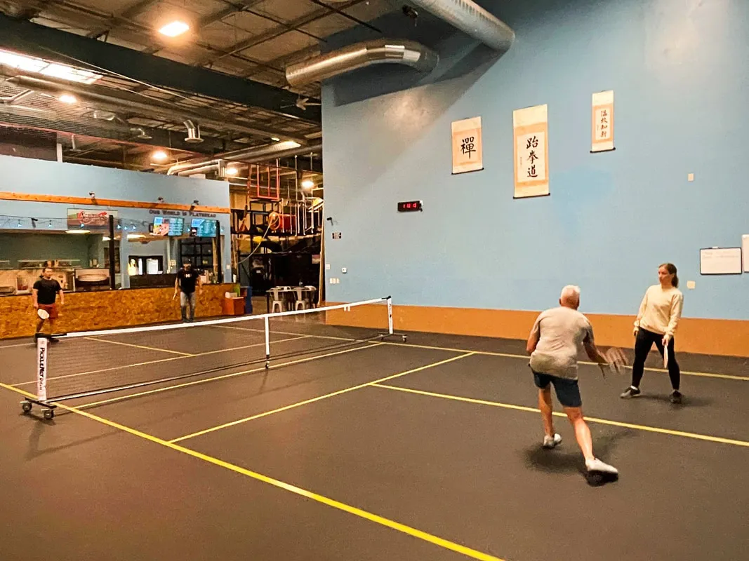 Adults playing indoor pickleball at Bodies in Motion