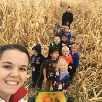 Preschoolers with pumpkins during a fall classroom activity