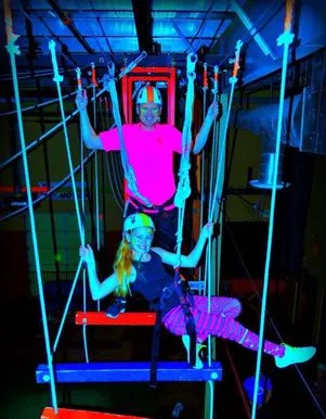 Climbers on the high aerial ropes course at Bodies in Motion