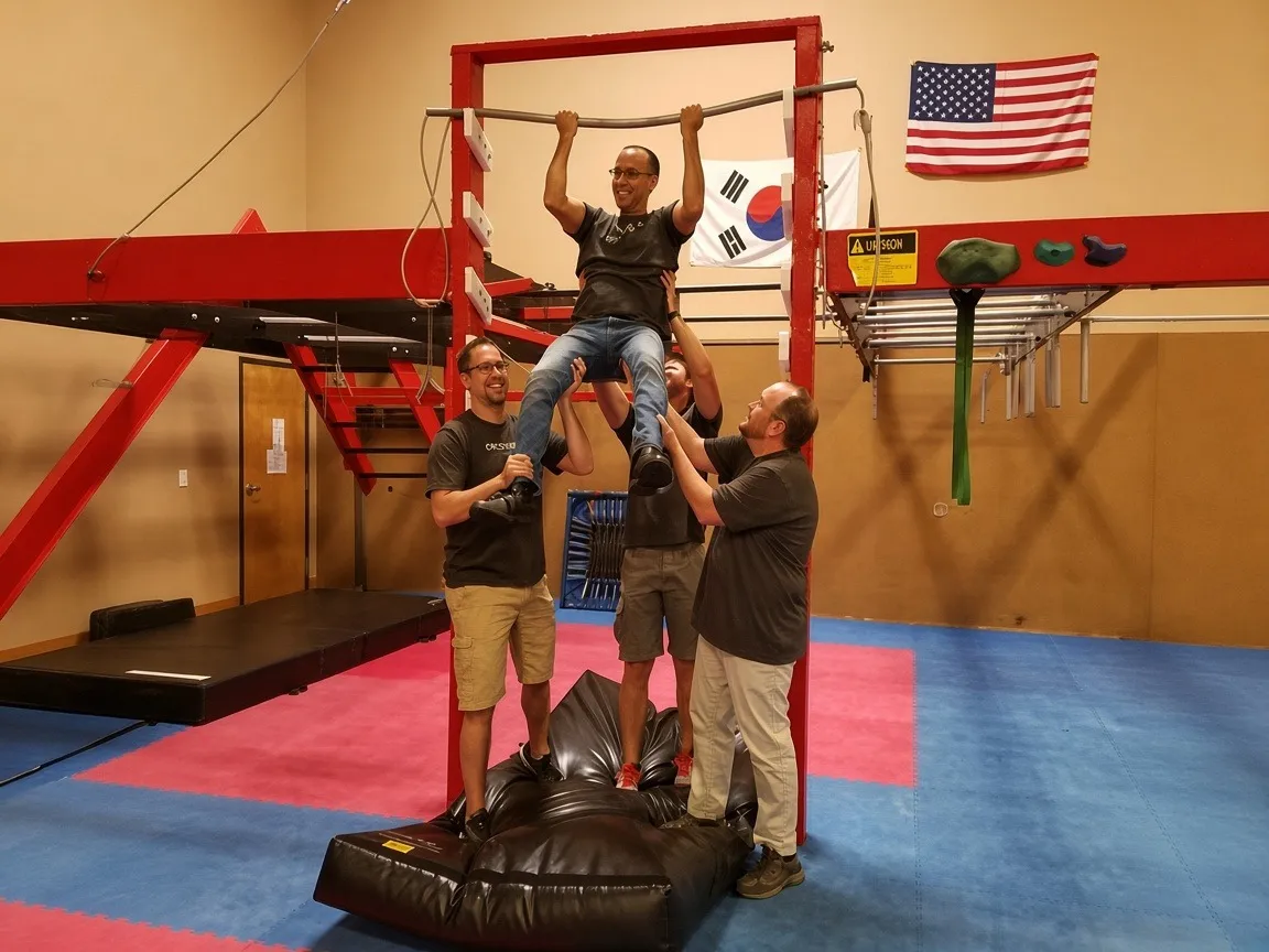 Coworkers tackling ninja warrior obstacles during a team-building workshop