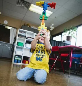 A proud young child showing off a classroom creation