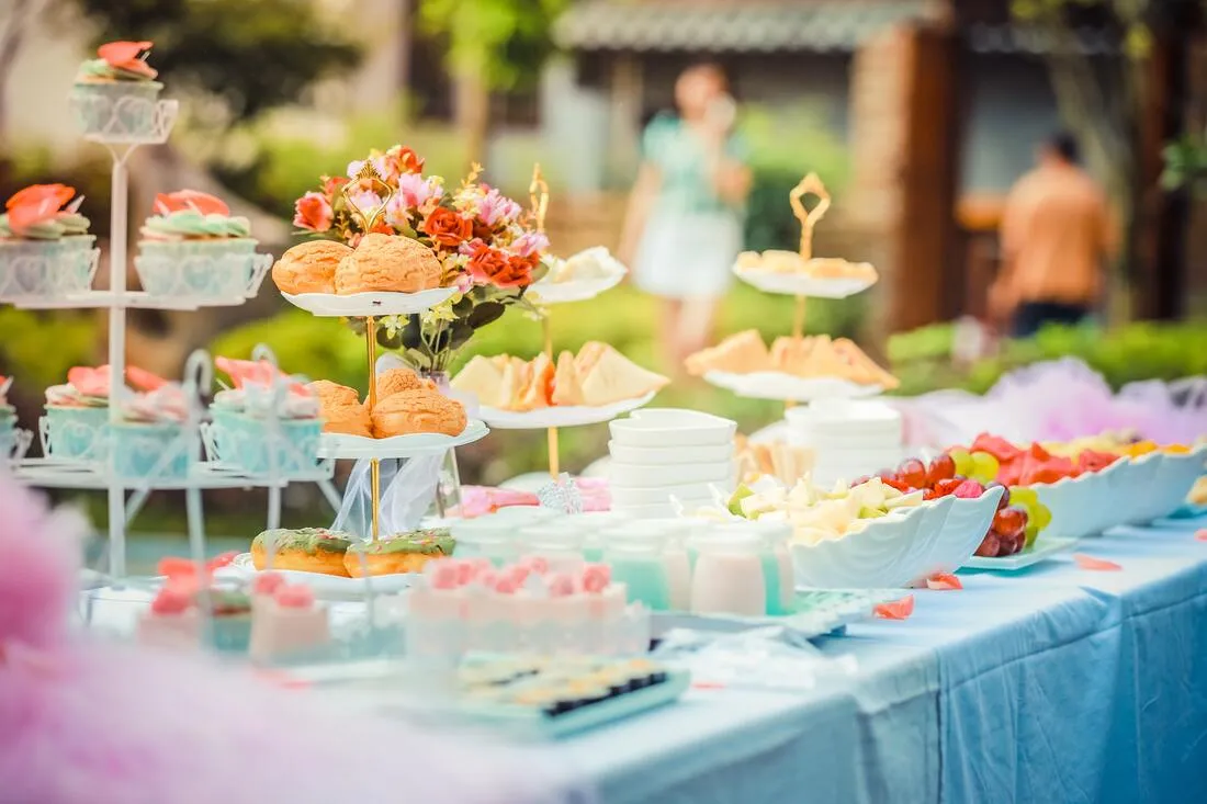 A birthday party table with cupcakes, pastries and fruit